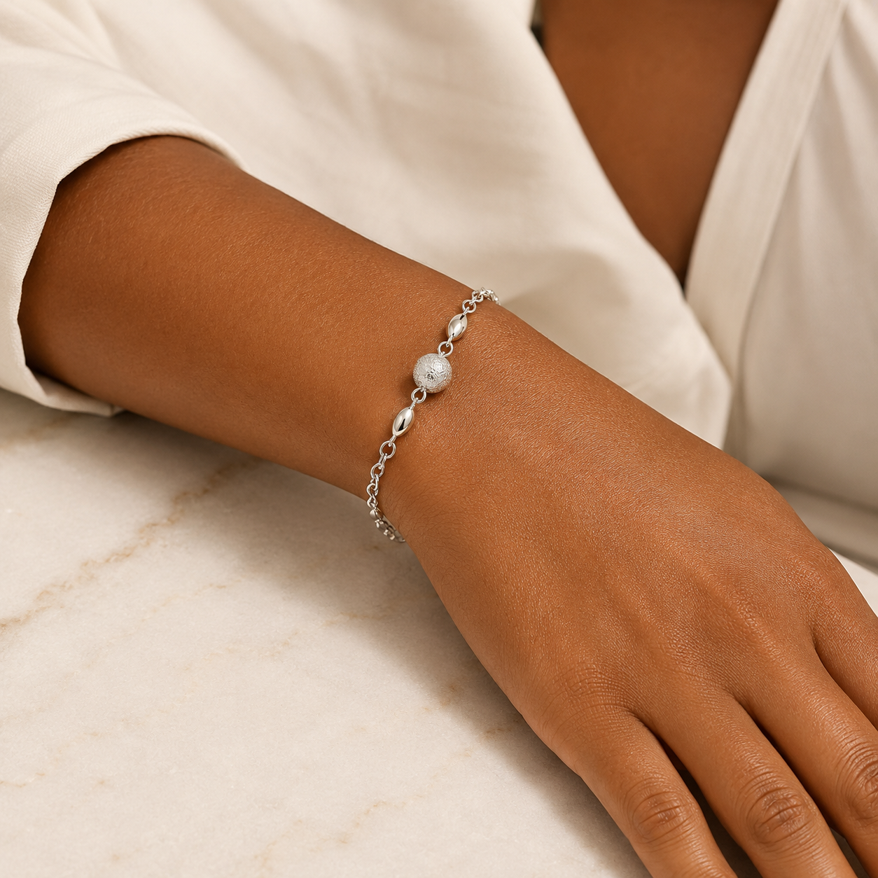 Pulseira Prateada com Esfera Central Texturizada e Detalhes Ovais - Imagem 2