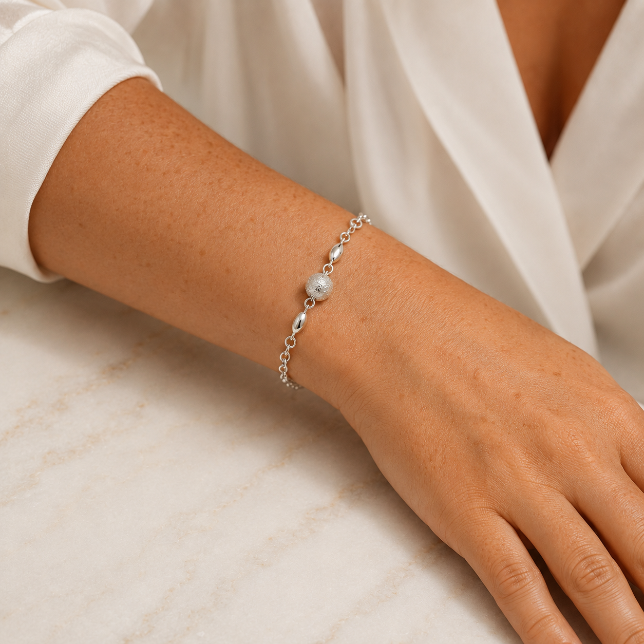 Pulseira Prateada com Esfera Central Texturizada e Detalhes Ovais - Imagem 3